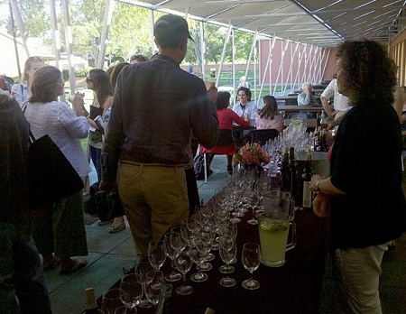 A volunteer staffs the wine table at the conference